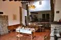 Speisesaal mit Steinwänden, Holzbalken und gedecktem Tisch.