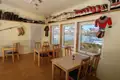 Blick aus dem Restaurant auf die Eisberge und die umliegende Landschaft. Traditionelle grönländische Kleidung und Schuhe sind Teil der Dekoration.