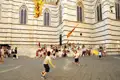 Kinder spielen mit Fahnen vor dem Dom.