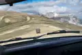 Fahrt im Geländewagen auf einer Bergstraße mit Blick auf einen schneebedeckten Gipfel.