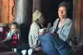 Drei Generationen einer Familie sitzen beisammen: Ein kleines Kind, eine ältere Frau und eine weitere ältere Person.