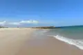 Strand mit Steinbuhne und leichtem Wellengang.