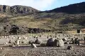 Felsige Landschaft mit verstreuten Steinen und einer Schutzhütte, typisch für die Region.