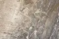 Historische Felsmalerei, die möglicherweise Tiere und menschliche Figuren darstellt.