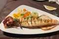 Gegrillter Tintenfisch serviert mit Gemüse.