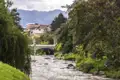 Fluss mit Brücke und Bergen im Hintergrund.