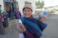 Frau mit Kind im Tragetuch.