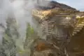 Vulkanische Aktivität mit Dampf und terrassierten Hängen.