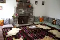 Traditioneller Wohnraum mit Kamin und Sitzgelegenheiten.