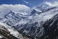 Schneebedeckte Berge im Hintergrund und ein verschneites Tal im Vordergrund.