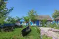 Traditionelle Häuser mit blau-weißer Fassade und Reetdach, typisch für die Region.
