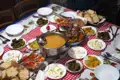 Tisch mit verschiedenen lokalen Gerichten, wie Suppe, Fleisch, gefüllte Weinblätter und Salat, die während der Reise genossen wurden.