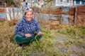 Frau mit geernteter Karotte im Garten.
