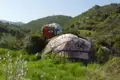 Bemalter Felsen in einer Hügellandschaft.
