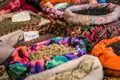 Verschiedene Gewürze in bunten, gemusterten Säcken auf einem Markt.