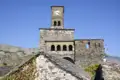 Uhrenturm und Steinmauern einer historischen Stätte.