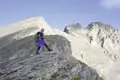 Wanderer auf einem Bergpfad mit Blick auf einen Berggipfel.