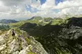 Wanderer auf einem Berggrat inmitten einer Berglandschaft.