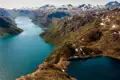 Panoramablick auf einen Fjord und schneebedeckte Berge.