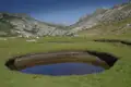 Wanderer in einer Berglandschaft mit kleinem See.
