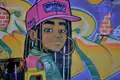 Graffiti-Kunstwerk einer jungen Frau an einer Wand.