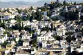 Blick über die Dächer des Albaicín-Viertels mit seinen weiß getünchten Häusern und grünen Bäumen in Granada, Spanien.
