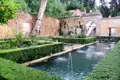 Wasserspiele und Hecken in einem Garten.