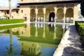 Reflektion eines Gebäudes mit Bögen in einem Wasserbecken.