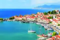 Hafenstadt mit traditionellen roten Dächern und Segelbooten im türkisblauen Wasser.