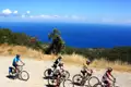Radfahrer auf einer Küstenstraße mit Blick auf das Meer.