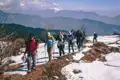 Wandergruppe auf einem verschneiten Bergpfad in den Bergen.