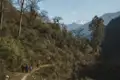 Wanderer auf einem Bergpfad im Himalaya mit Blick auf einen schneebedeckten Gipfel.