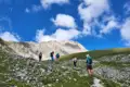 Wanderer auf einem Bergpfad mit Blick auf einen Berggipfel.