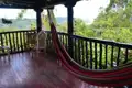 Hängematte auf einer Veranda mit Blick auf bewaldete Hügel.