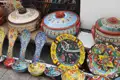 Handgefertigte Keramik: Ausstellung von bemalten Töpfen, Tellern und Löffeln mit traditionellen Mustern.