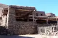 Traditionelles Steinhaus mit Holzbalken und einem Holzzaun.