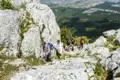 Wanderer bewältigen einen anspruchsvollen, felsigen Aufstieg im Gebirge.