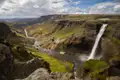 Spektakulärer Wasserfall, der in eine felsige Schlucht stürzt und von einem Fluss durchflossen wird.