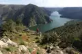 Wanderer auf einem Aussichtspunkt mit Blick auf den Fluss und die Berge.
