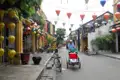Traditionelle Straße mit bunten Laternen und einem Rikschafahrer.