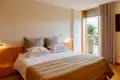 Schlafzimmer mit Doppelbett, Kissen und Zugang zum Balkon.
