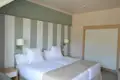 Zwei Einzelbetten in einem Hotelzimmer mit gestreiften Wänden und einem Kleiderschrank.
