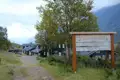 Das Willkommensschild zur Gjendebu DNT-Hütte mit den Hütten im Hintergrund.