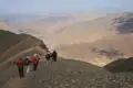 Wanderer auf einem Bergpfad in einer bergigen Landschaft.