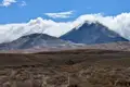 Zwei Berge in einer Landschaft, einer davon teilweise von Wolken verdeckt.
