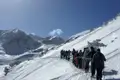 Gruppe von Schneeschuhwanderern auf einem verschneiten Bergpfad.