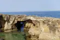 Erodierte Küstenfelsen mit einem natürlichen Bogen und Blick aufs Meer.