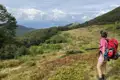 Wanderer auf einem Bergpfad mit Blick auf eine Bergkette.