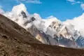 Beeindruckende Berglandschaft mit schneebedeckten Gipfeln und Wolkenformationen.