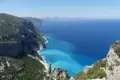 Felsige Küste mit türkisblauem Meer.